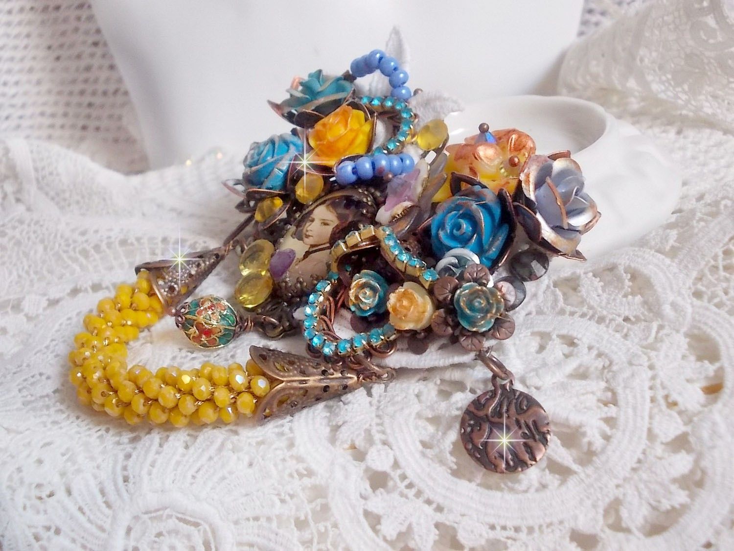 Broche artisanale baroque fleurie avec perles et cristaux colorés.