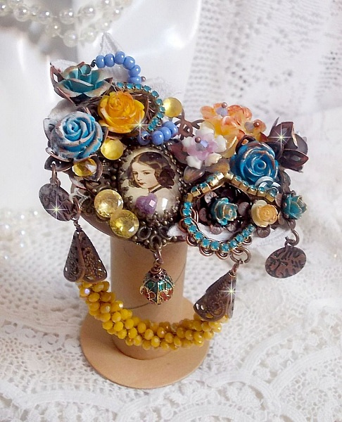 Broche artisanale baroque ornée de fleurs, cristaux et perles.