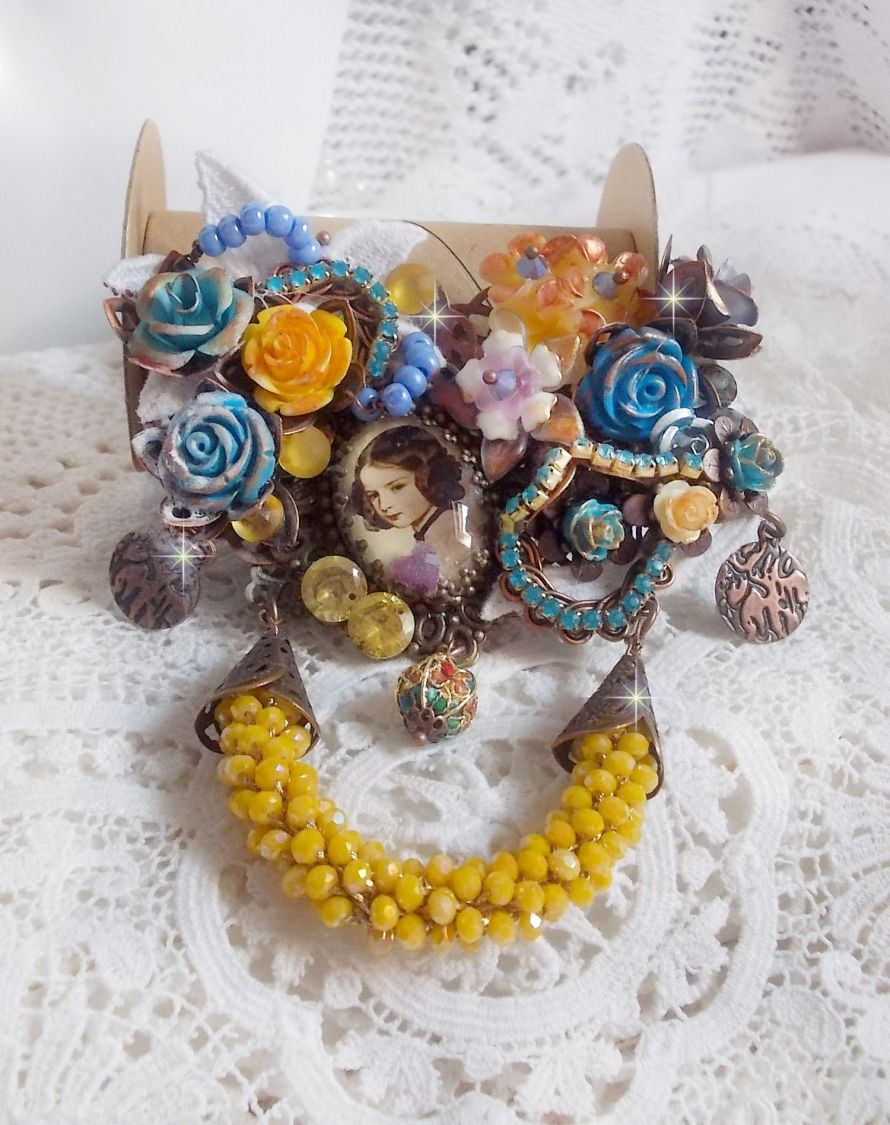 Broche artisanale baroque ornée de fleurs et perles jaunes.