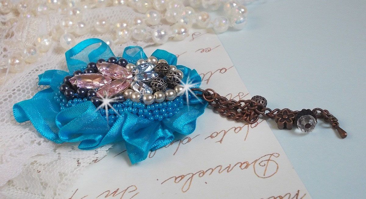 Broche Belle Epoque Haute-Couture est brod&eacute;e avec des Cristaux de Swarovski, des perles rondes nacr&eacute;es, des breloques, un ruban et des rocailles