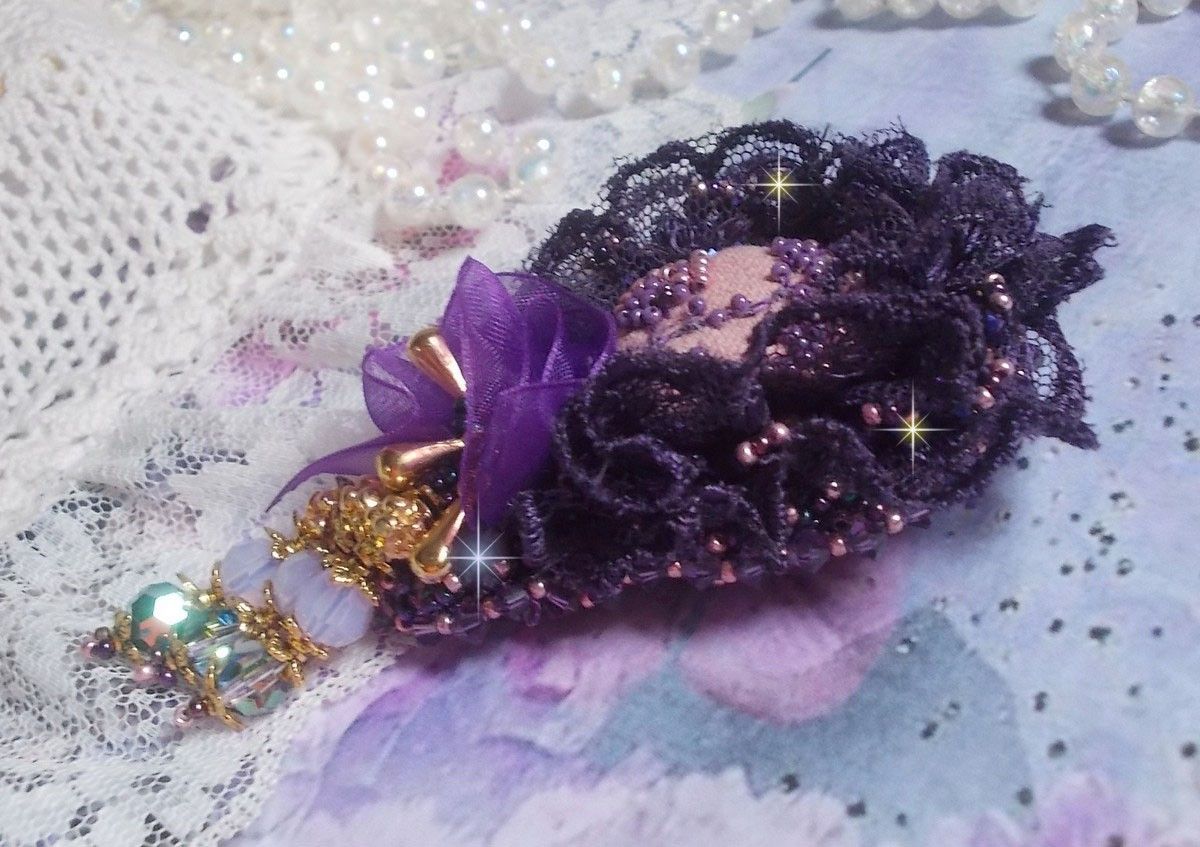 Broche Lady Romantique brod&eacute;e avec une dentelle violine ann&eacute;e 1950 avec un tissu en lin vieux rose brod&eacute; de fleurs et branches en rocailles bord&eacute; d&rsquo;un ruban organza, fleurs, cristaux et breloques