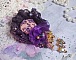 Broche Lady Romantique brod&eacute;e avec une dentelle violine ann&eacute;e 1950 avec un tissu en lin vieux rose brod&eacute; de fleurs et branches en rocailles bord&eacute; d&rsquo;un ruban organza, fleurs, cristaux et breloques