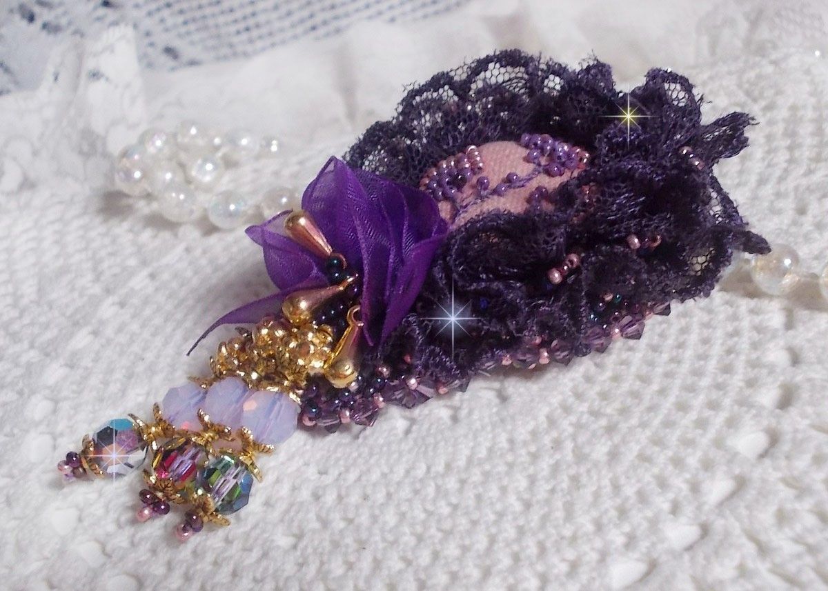 Broche Lady Romantique brod&eacute;e avec une dentelle violine ann&eacute;e 1950 avec un tissu en lin vieux rose brod&eacute; de fleurs et branches en rocailles bord&eacute; d&rsquo;un ruban organza, fleurs, cristaux et breloques