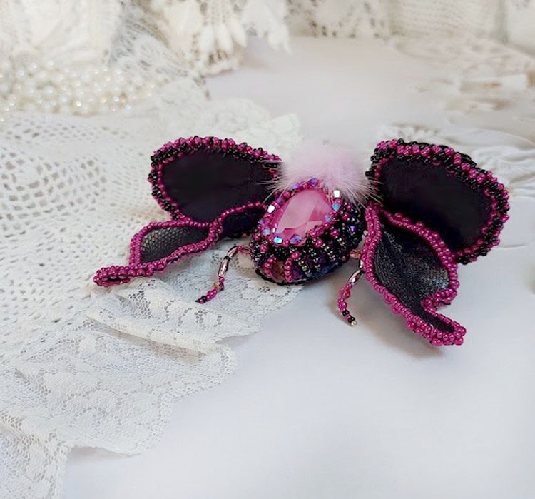 Broche insecte artisanale brodée en perles rose fuchsia et noir.