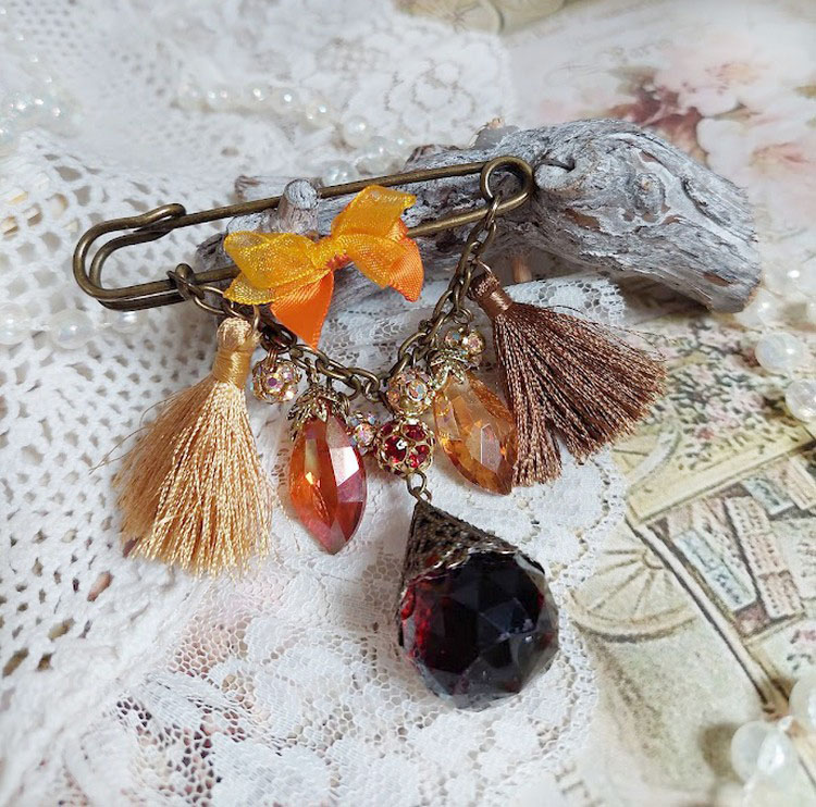 Broche épingle fantaisie avec pompons, strass et perles verre.