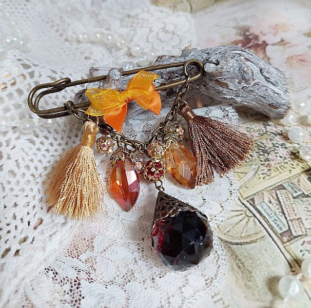 Broche épingle fantaisie avec pompons, strass et perles verre.