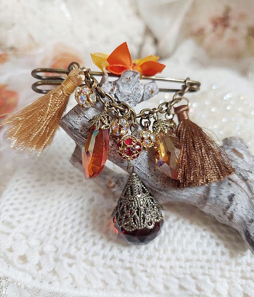 Broche artisanale automnale avec strass, pompons et gouttes verre.