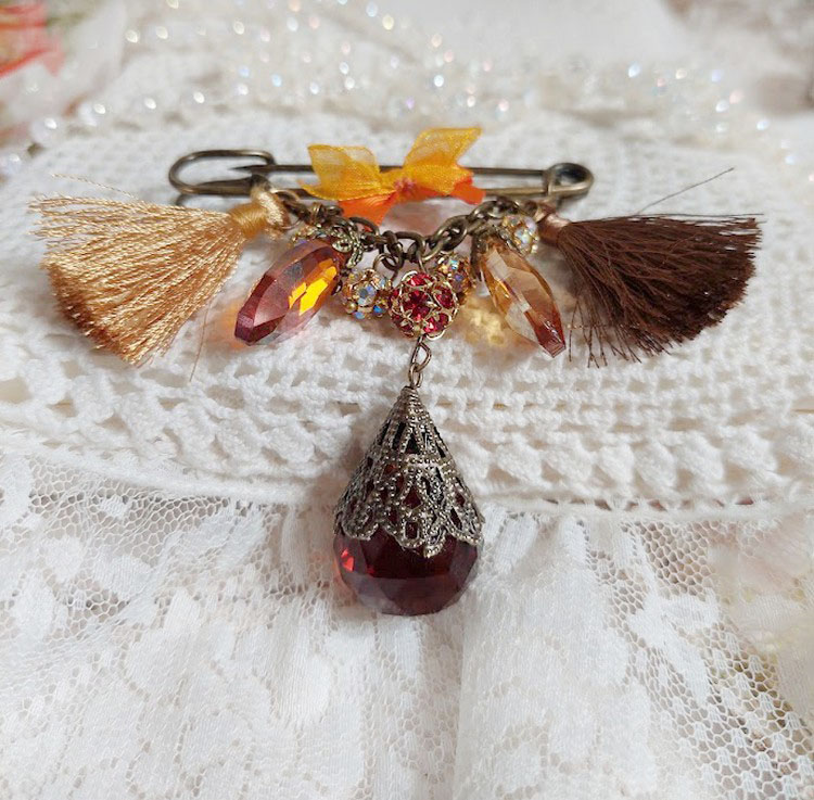 Broche artisanale Méline des Bois avec pompons et strass.