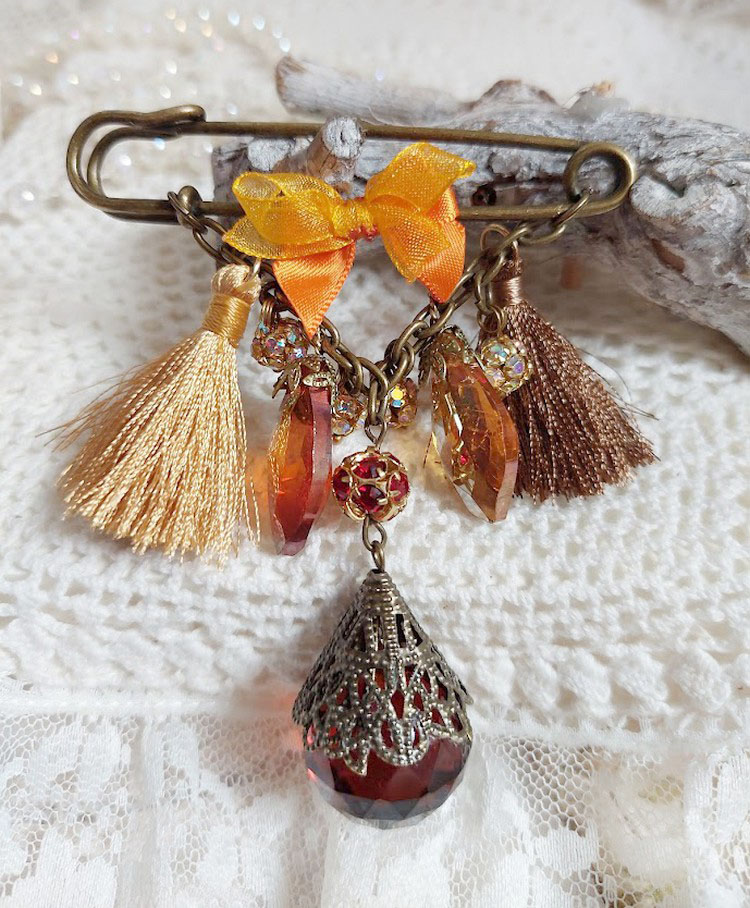 Broche Méline des Bois avec pompons, strass et gouttes verre.