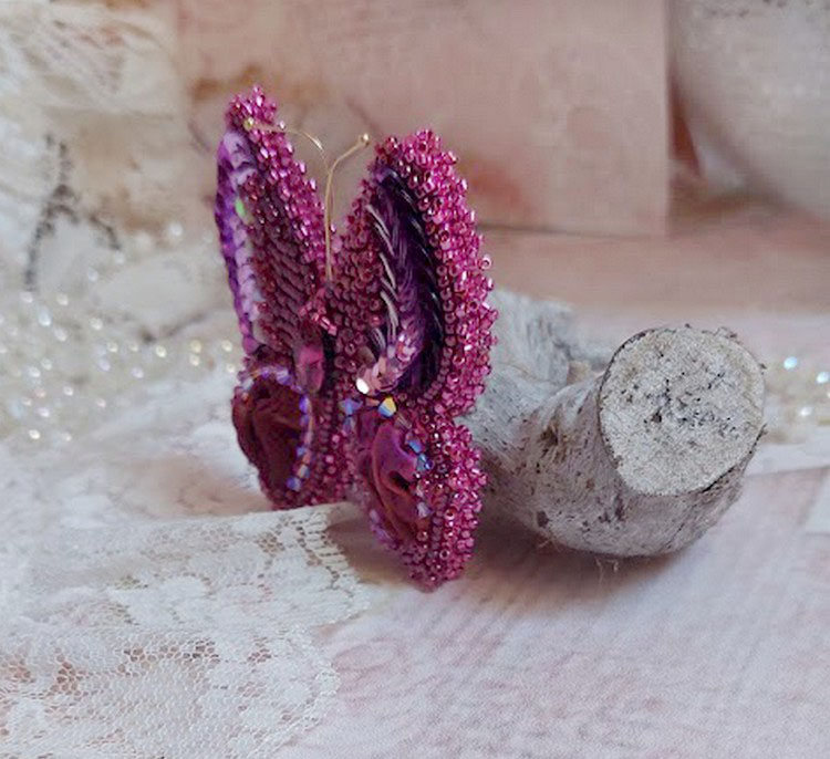 Broche papillon artisanale brodée en perles fuchsia et soie.