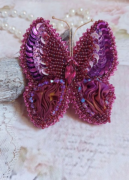 Broche papillon brodée en soie, sequins et cristaux fuchsia.