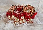 Broche Rubis brod&eacute;e avec trois cabochons Ivoire et Rouge &agrave; laquelle s&rsquo;ajoute des toupies aux couleurs Cristal, Burgundy et Garnet, des perles nacr&eacute;es et opaque. Mont&eacute; sur une dentelle et une broche