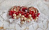 Broche Rubis brod&eacute;e avec trois cabochons Ivoire et Rouge &agrave; laquelle s&rsquo;ajoute des toupies aux couleurs Cristal, Burgundy et Garnet, des perles nacr&eacute;es et opaque. Mont&eacute; sur une dentelle et une broche