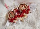 Broche Rubis brod&eacute;e avec trois cabochons Ivoire et Rouge &agrave; laquelle s&rsquo;ajoute des toupies aux couleurs Cristal, Burgundy et Garnet, des perles nacr&eacute;es et opaque. Mont&eacute; sur une dentelle et une broche