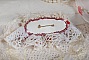 Broche Rubis brod&eacute;e avec trois cabochons Ivoire et Rouge &agrave; laquelle s&rsquo;ajoute des toupies aux couleurs Cristal, Burgundy et Garnet, des perles nacr&eacute;es et opaque. Mont&eacute; sur une dentelle et une broche