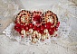Broche Rubis brod&eacute;e avec trois cabochons Ivoire et Rouge &agrave; laquelle s&rsquo;ajoute des toupies aux couleurs Cristal, Burgundy et Garnet, des perles nacr&eacute;es et opaque. Mont&eacute; sur une dentelle et une broche