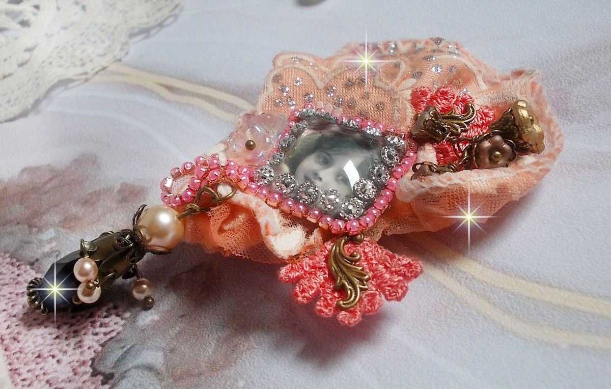 Broche Rustic Rose cr&eacute;e avec un cabochon repr&eacute;sentant une jeune fille souriante, de la dentelle Orange strass&eacute; et Rose, des cristaux, des perles en verre et des accessoires divers
