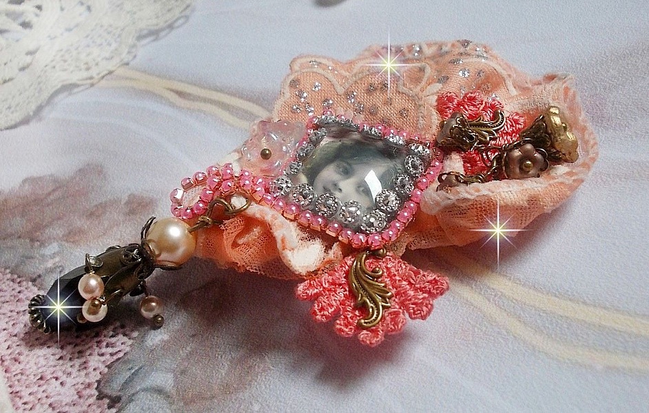 Broche Rustic Rose cr&eacute;e avec un cabochon repr&eacute;sentant une jeune fille souriante, de la dentelle Orange strass&eacute; et Rose, des cristaux, des perles en verre et des accessoires divers