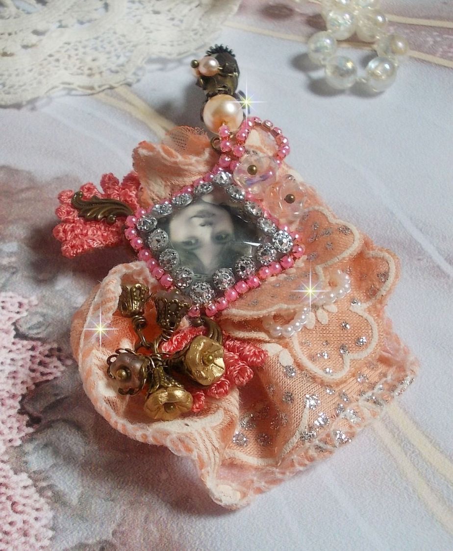 Broche Rustic Rose cr&eacute;e avec un cabochon repr&eacute;sentant une jeune fille souriante, de la dentelle Orange strass&eacute; et Rose, des cristaux, des perles en verre et des accessoires divers