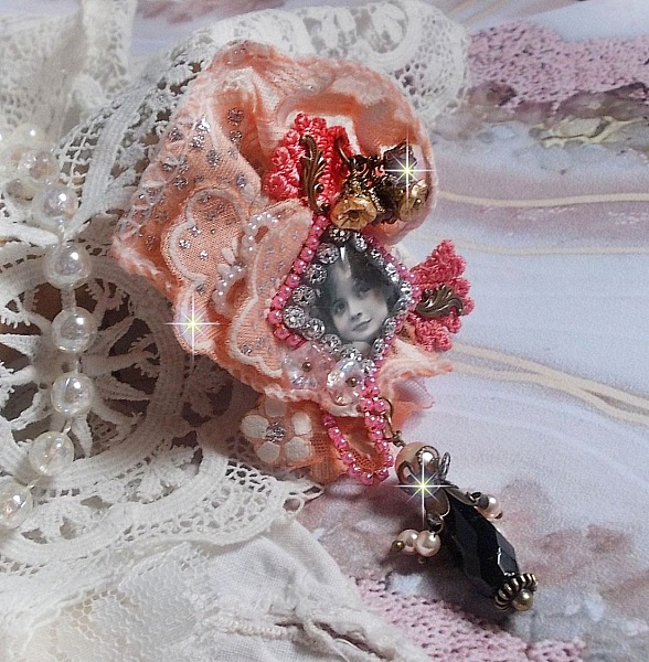 Broche Rustic Rose cr&eacute;e avec un cabochon repr&eacute;sentant une jeune fille souriante, de la dentelle Orange strass&eacute; et Rose, des cristaux, des perles en verre et des accessoires divers