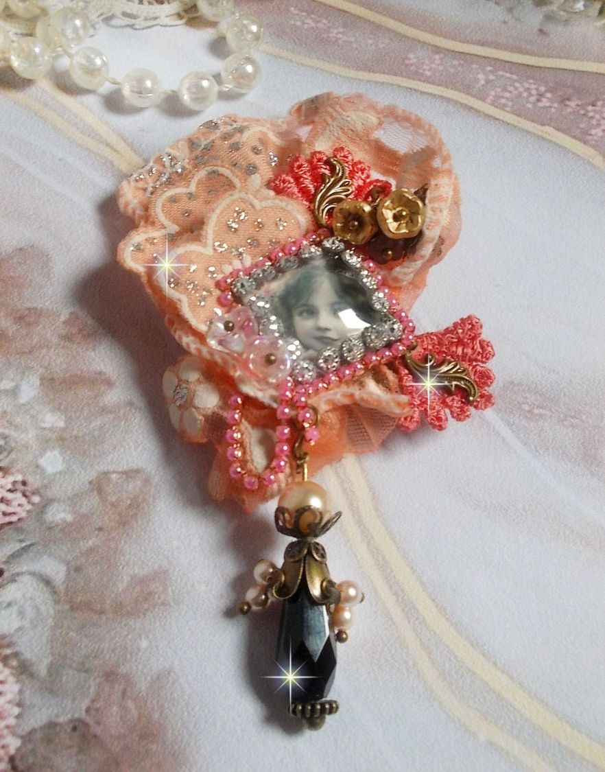 Broche Rustic Rose cr&eacute;e avec un cabochon repr&eacute;sentant une jeune fille souriante, de la dentelle Orange strass&eacute; et Rose, des cristaux, des perles en verre et des accessoires divers