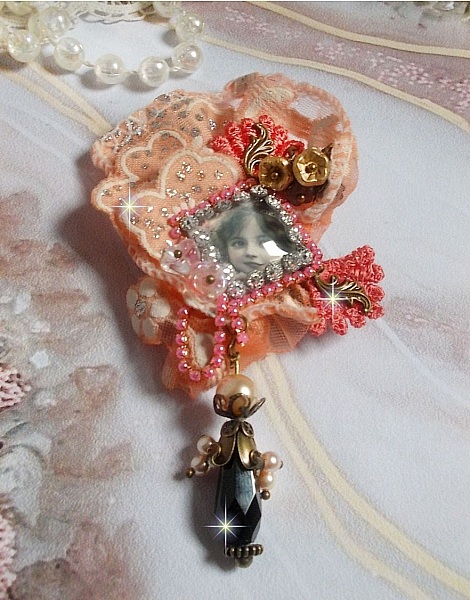 Broche Rustic Rose cr&eacute;e avec un cabochon repr&eacute;sentant une jeune fille souriante, de la dentelle Orange strass&eacute; et Rose, des cristaux, des perles en verre et des accessoires divers