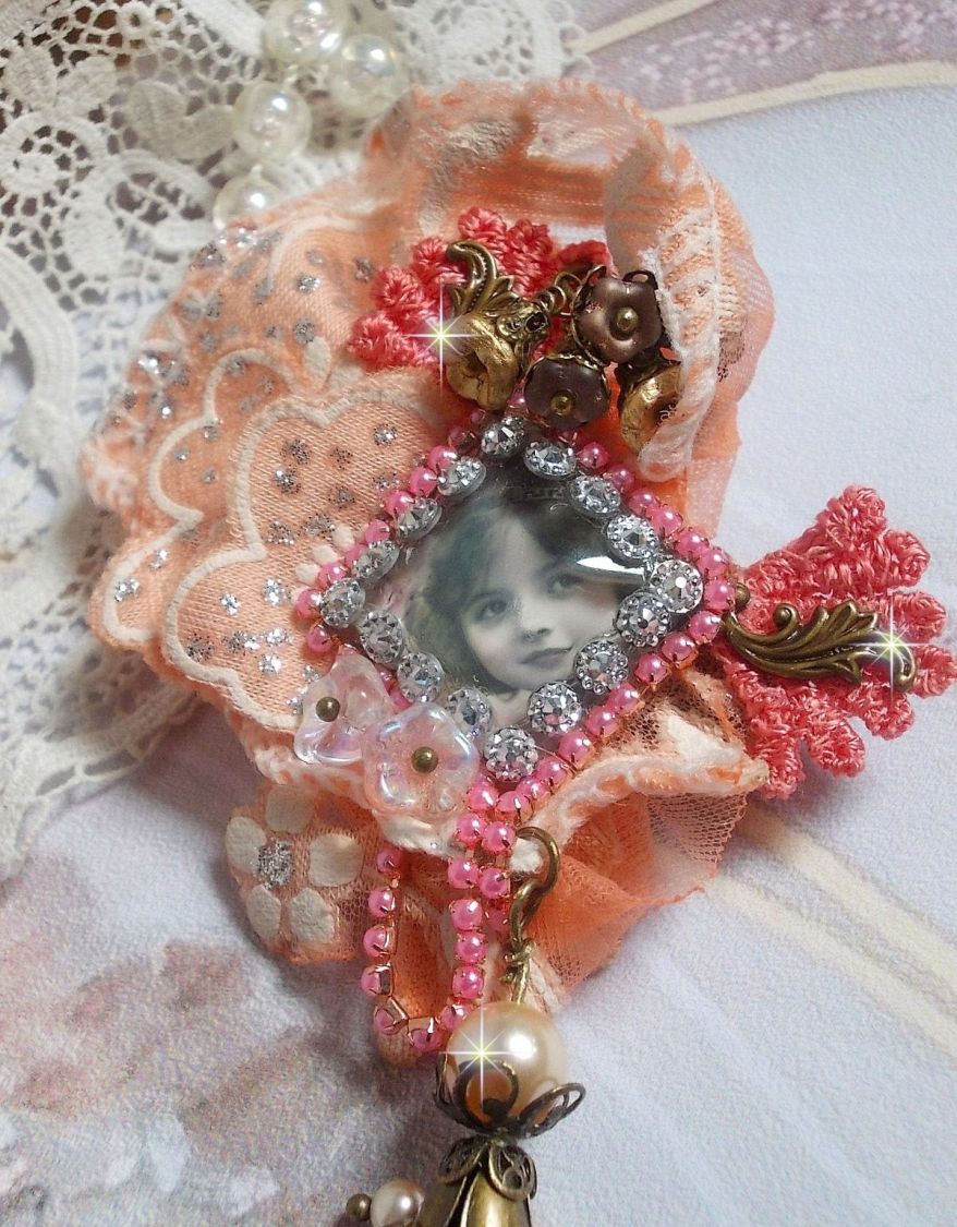 Broche Rustic Rose cr&eacute;e avec un cabochon repr&eacute;sentant une jeune fille souriante, de la dentelle Orange strass&eacute; et Rose, des cristaux, des perles en verre et des accessoires divers