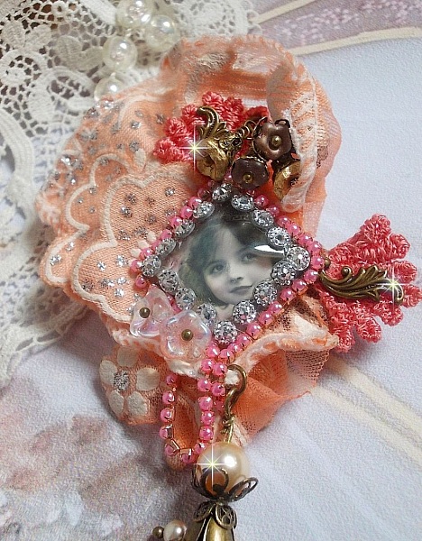 Broche Rustic Rose cr&eacute;e avec un cabochon repr&eacute;sentant une jeune fille souriante, de la dentelle Orange strass&eacute; et Rose, des cristaux, des perles en verre et des accessoires divers
