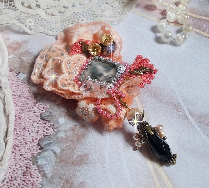 Broche Rustic Rose cr&eacute;e avec un cabochon repr&eacute;sentant une jeune fille souriante, de la dentelle Orange strass&eacute; et Rose, des cristaux, des perles en verre et des accessoires divers