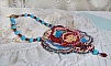Collier artisanal brodé avec cabochon rétro et perles colorées.