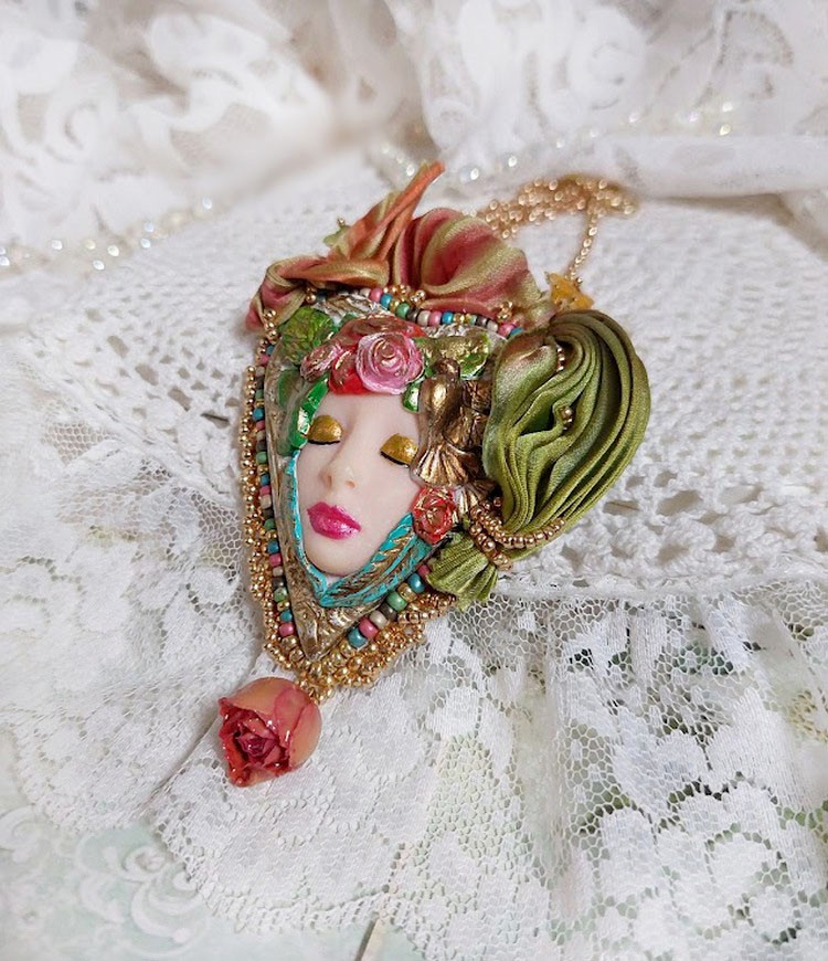 Collier artisanal féérique avec visage en pâte polymère et rubans.