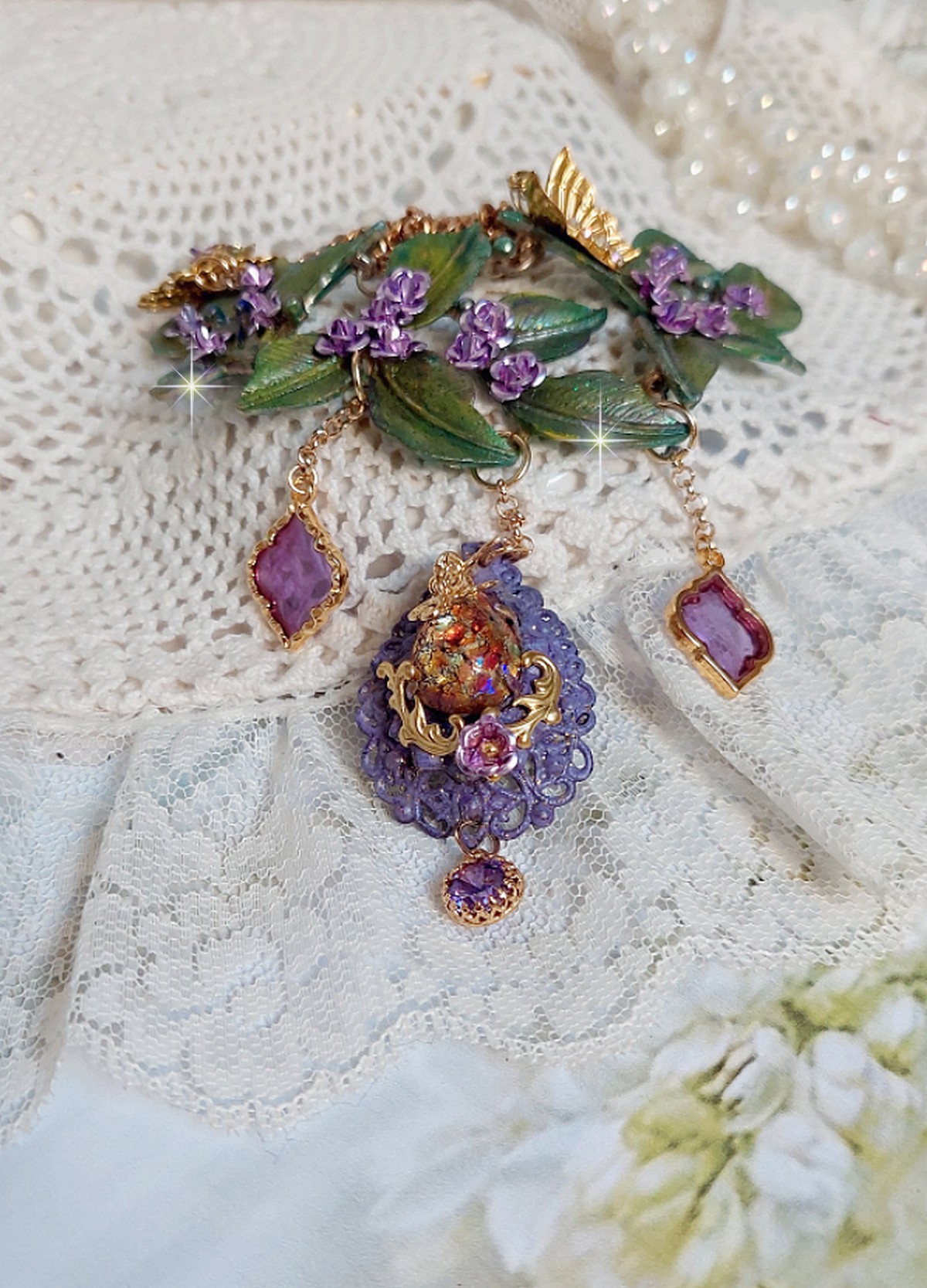 Collier Cam&eacute;lia Japonica mont&eacute; avec un motif feuilles aquarell&eacute;s &agrave; la main, paillettes, breloques papillons et abeille, roses m&eacute;tal, cabochon cristal, pendentifs &eacute;poxy aux couleurs d&rsquo;arc en ciel