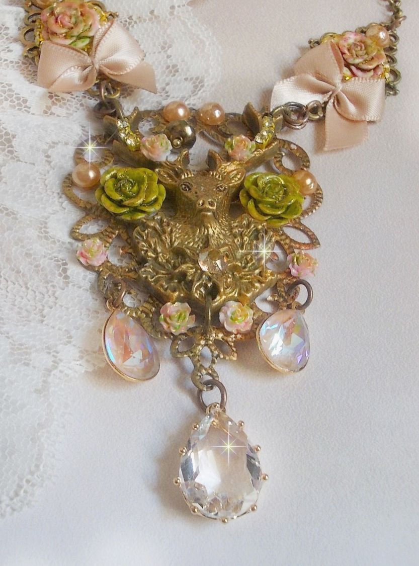Collier Cerf Fleuri cr&eacute;e avec des cristaux de Swarovski, cabochons en r&eacute;sine, perles en verre, t&ecirc;te de cerf avec bois en m&eacute;tal, pendentif larme en zircon, n&oelig;uds en satin et accessoires en laiton 