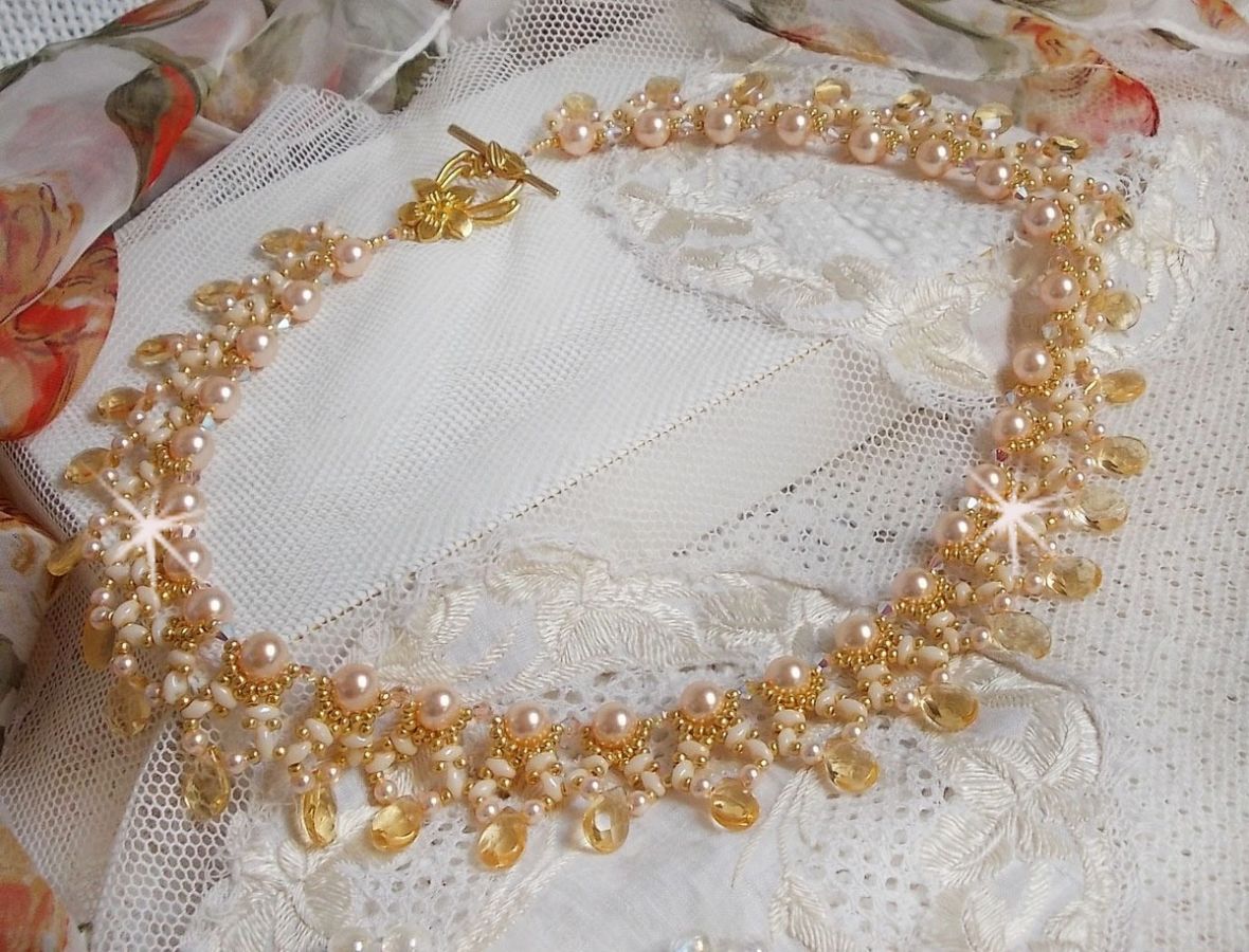 Collier Charmeuse Champagne Champagne avec des cristaux : perles nacr&eacute;es/toupies, gouttes en verre et rocailles. Aux couleurs Gold, P&ecirc;che, Jaune et Beige pour les beaux reflets du soleil. 