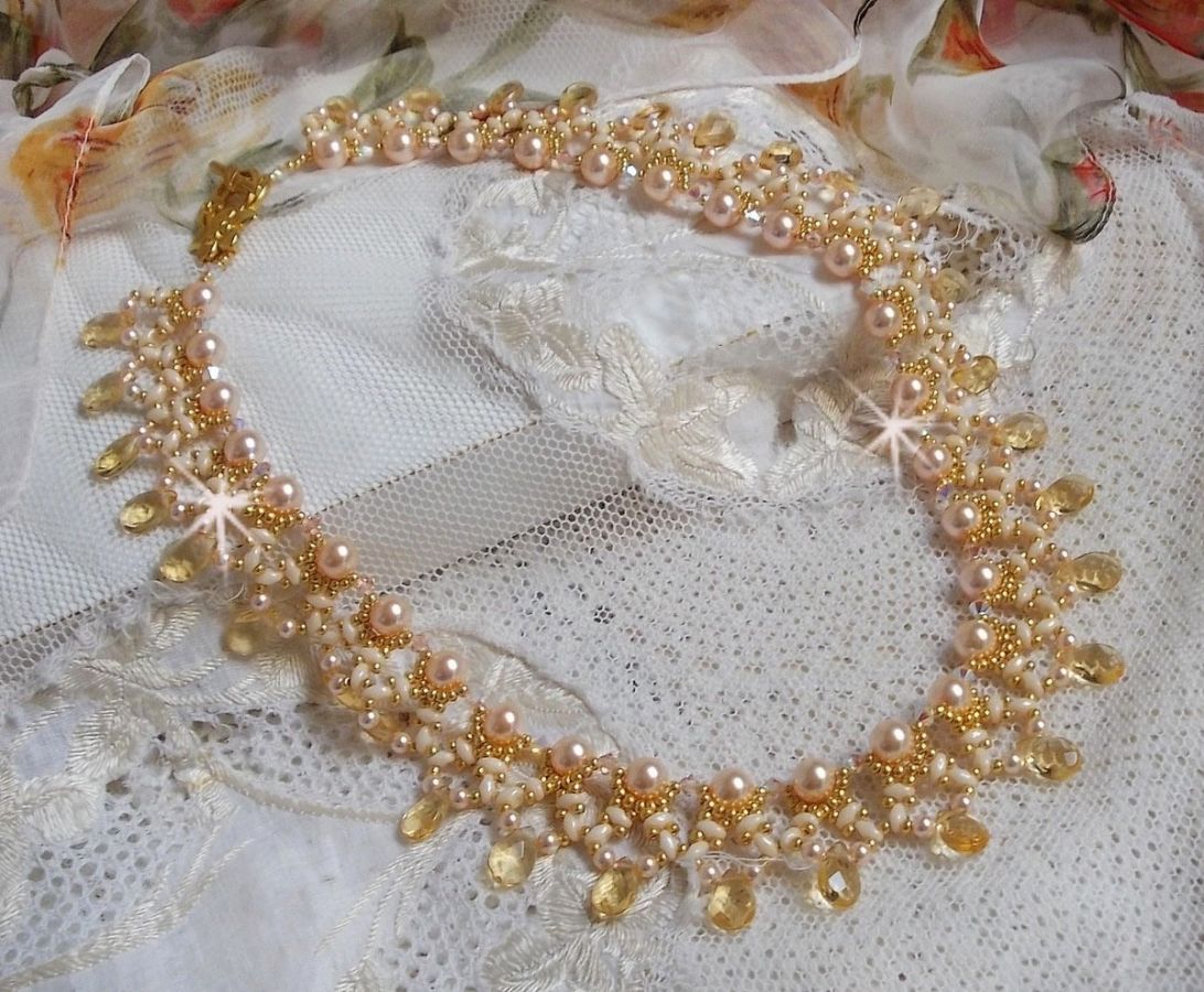 Collier Charmeuse Champagne Champagne avec des cristaux : perles nacr&eacute;es/toupies, gouttes en verre et rocailles. Aux couleurs Gold, P&ecirc;che, Jaune et Beige pour les beaux reflets du soleil. 