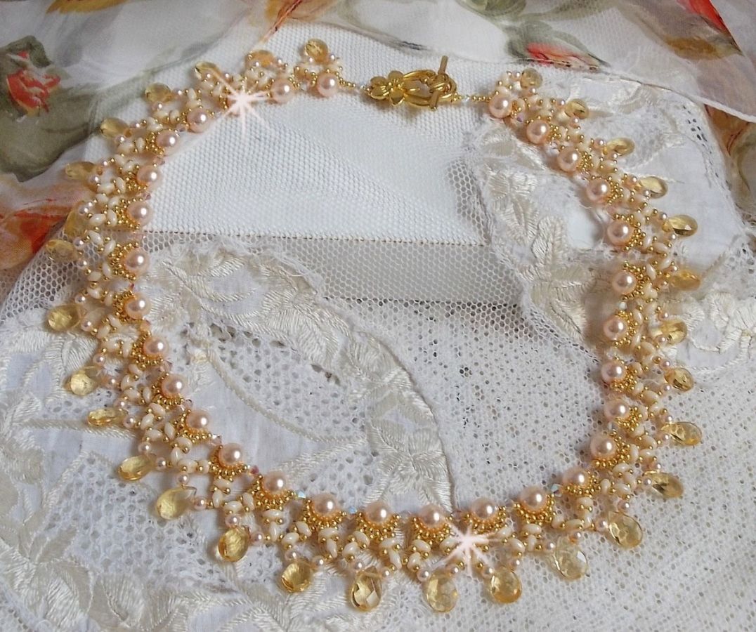 Collier Charmeuse Champagne Champagne avec des cristaux : perles nacr&eacute;es/toupies, gouttes en verre et rocailles. Aux couleurs Gold, P&ecirc;che, Jaune et Beige pour les beaux reflets du soleil. 