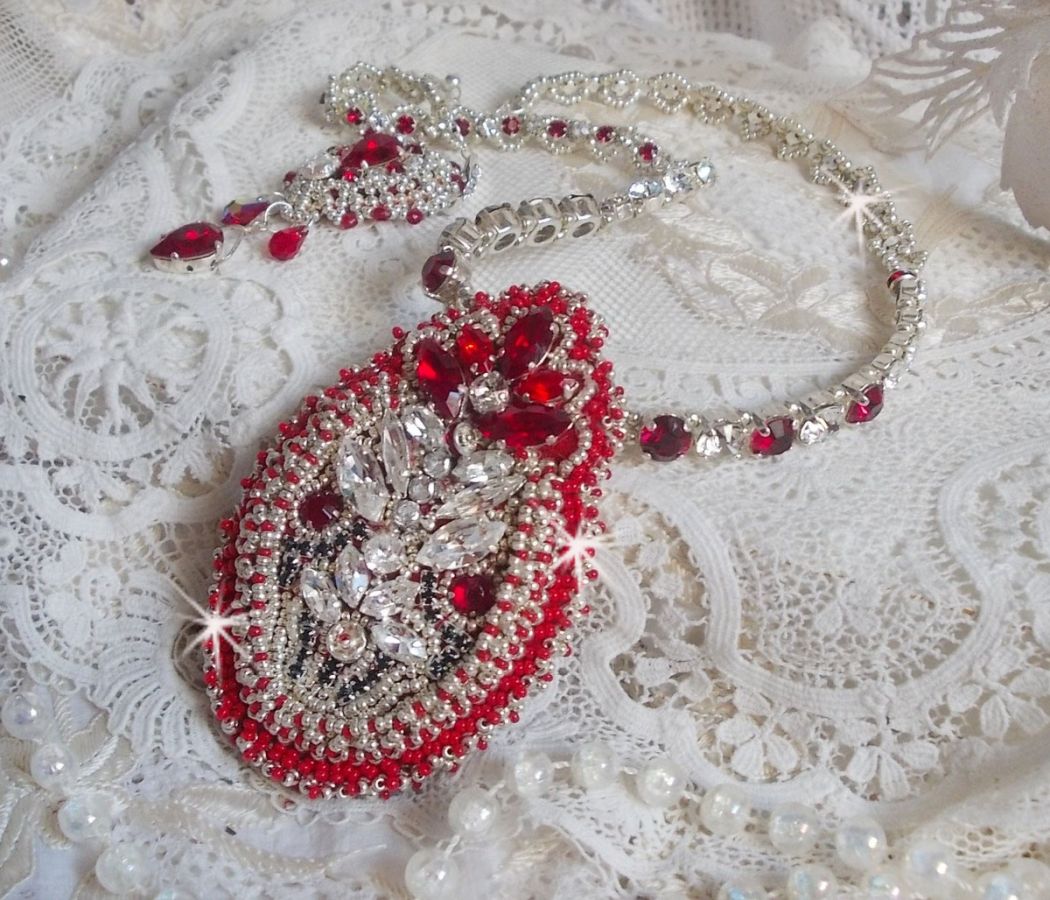 Collier Drigon Red brod&eacute; avec des navettes et cabochons aux couleurs Rouge, Cristal et Argent&eacute;, repr&eacute;sentant une femme Dragon, strass, rocailles, facettes, cha&icirc;nettes et fermoirs en argent 925/1000