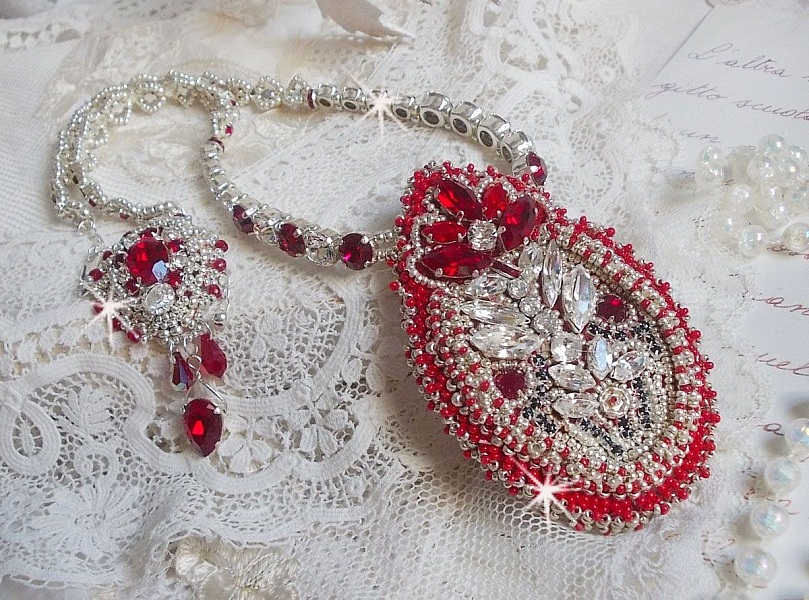 Collier Drigon Red brod&eacute; avec des navettes et cabochons aux couleurs Rouge, Cristal et Argent&eacute;, repr&eacute;sentant une femme Dragon, strass, rocailles, facettes, cha&icirc;nettes et fermoirs en argent 925/1000