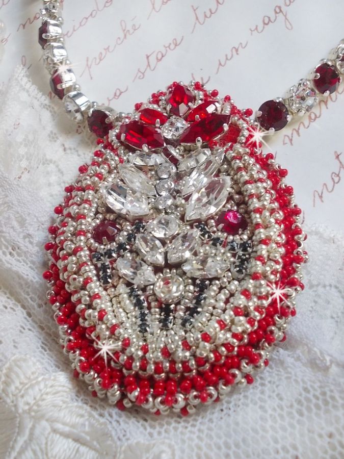 Collier Drigon Red brod&eacute; avec des navettes et cabochons aux couleurs Rouge, Cristal et Argent&eacute;, repr&eacute;sentant une femme Dragon, strass, rocailles, facettes, cha&icirc;nettes et fermoirs en argent 925/1000