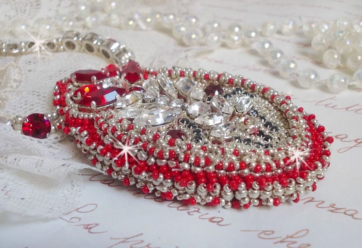 Collier Drigon Red brod&eacute; avec des navettes et cabochons aux couleurs Rouge, Cristal et Argent&eacute;, repr&eacute;sentant une femme Dragon, strass, rocailles, facettes, cha&icirc;nettes et fermoirs en argent 925/1000