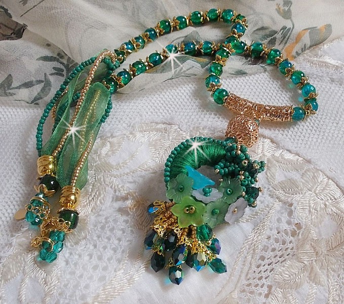 Collier Green Iris brod&eacute; avec du coton DMC Vert sur un anneau en bois avec fleurs Lucites, gouttes en cristal. Le tout est mont&eacute; avec perles rondes craquel&eacute;es, ruban organza et fermoir en argent 925