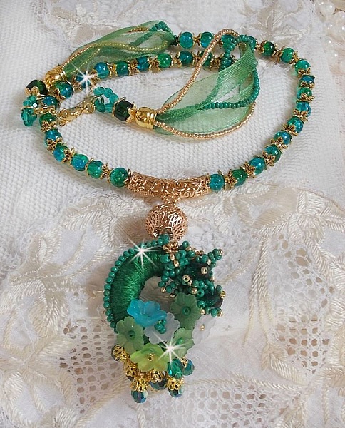 Collier Green Iris brod&eacute; avec du coton DMC Vert sur un anneau en bois avec fleurs Lucites, gouttes en cristal. Le tout est mont&eacute; avec perles rondes craquel&eacute;es, ruban organza et fermoir en argent 925