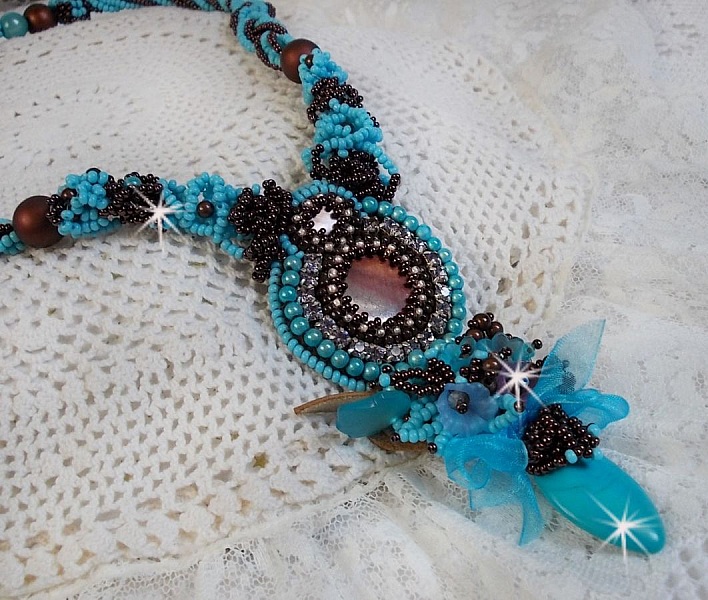 Collier Turquoise Haute Couture au Style Am&eacute;rindien brod&eacute; sur du Cuir avec des cabochons ronds Nacre Acajou et Prune, s&rsquo;ajoute un cabochon Turquoise. Orn&eacute; de cristaux, ruban, perles et rocailles 