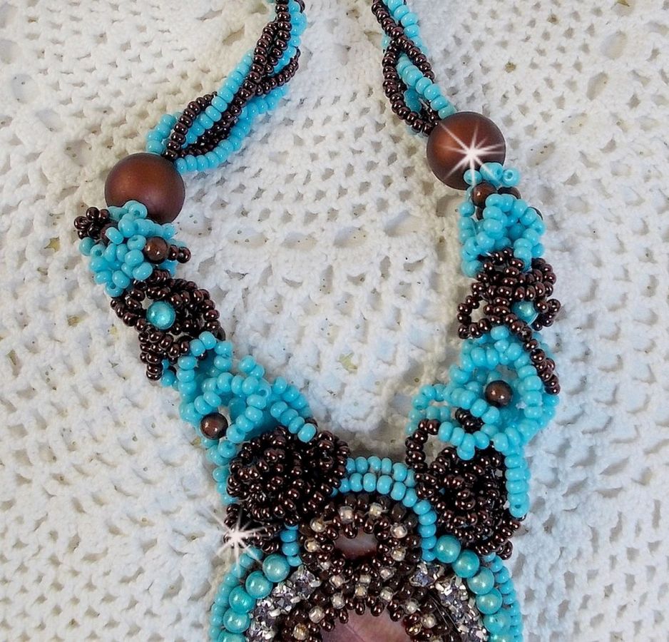 Collier Turquoise Haute Couture au Style Am&eacute;rindien brod&eacute; sur du Cuir avec des cabochons ronds Nacre Acajou et Prune, s&rsquo;ajoute un cabochon Turquoise. Orn&eacute; de cristaux, ruban, perles et rocailles 