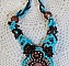Collier Turquoise Haute Couture au Style Am&eacute;rindien brod&eacute; sur du Cuir avec des cabochons ronds Nacre Acajou et Prune, s&rsquo;ajoute un cabochon Turquoise. Orn&eacute; de cristaux, ruban, perles et rocailles 