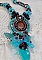 Collier Turquoise Haute Couture au Style Am&eacute;rindien brod&eacute; sur du Cuir avec des cabochons ronds Nacre Acajou et Prune, s&rsquo;ajoute un cabochon Turquoise. Orn&eacute; de cristaux, ruban, perles et rocailles 