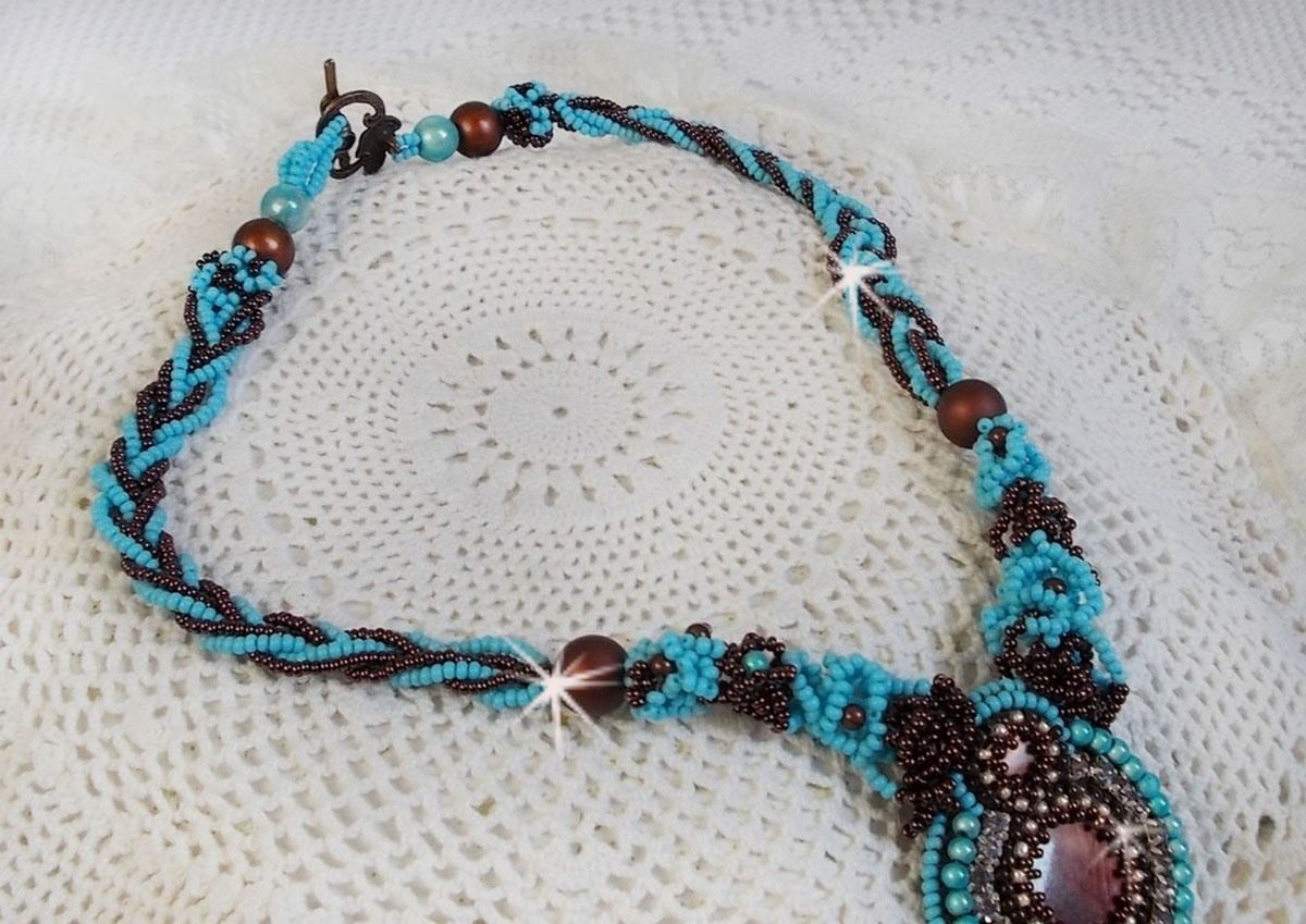 Collier Turquoise Haute Couture au Style Am&eacute;rindien brod&eacute; sur du Cuir avec des cabochons ronds Nacre Acajou et Prune, s&rsquo;ajoute un cabochon Turquoise. Orn&eacute; de cristaux, ruban, perles et rocailles 