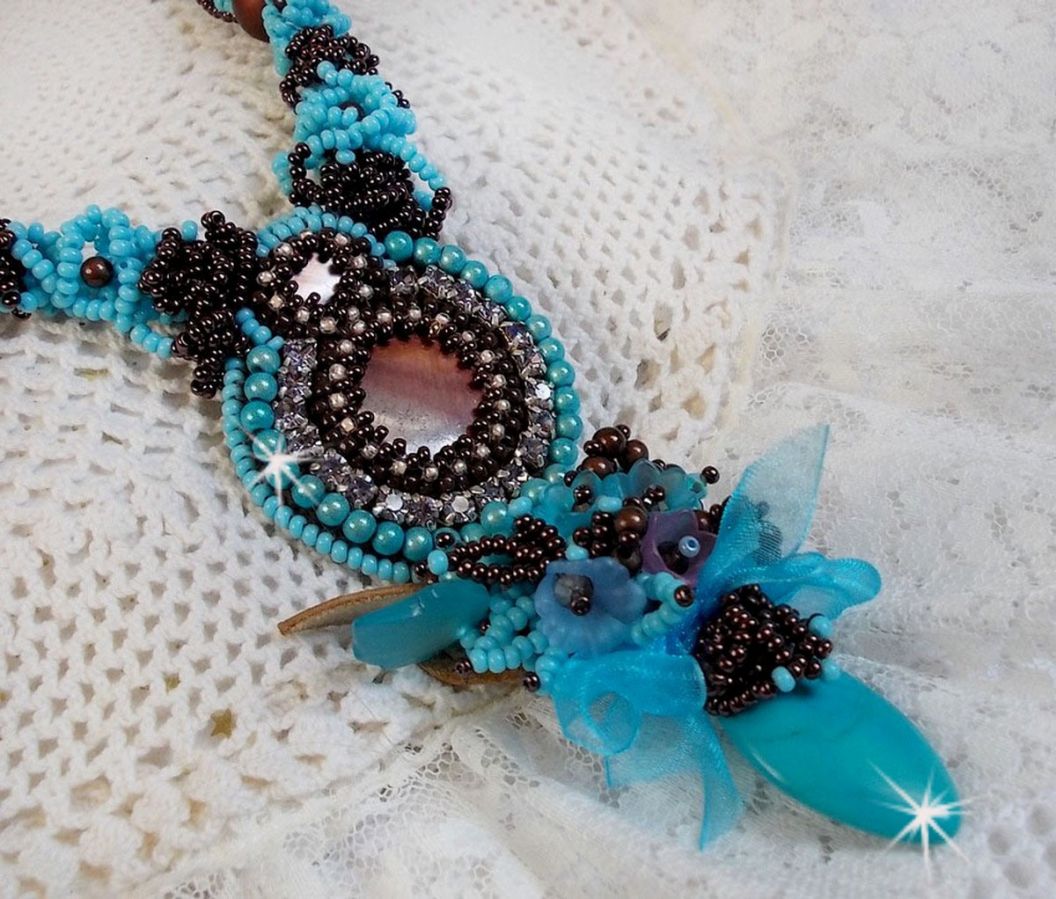 Collier Turquoise Haute Couture au Style Am&eacute;rindien brod&eacute; sur du Cuir avec des cabochons ronds Nacre Acajou et Prune, s&rsquo;ajoute un cabochon Turquoise. Orn&eacute; de cristaux, ruban, perles et rocailles 