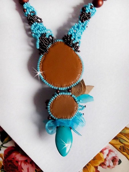 Collier Turquoise Haute Couture au Style Am&eacute;rindien brod&eacute; sur du Cuir avec des cabochons ronds Nacre Acajou et Prune, s&rsquo;ajoute un cabochon Turquoise. Orn&eacute; de cristaux, ruban, perles et rocailles 