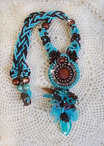 Collier Turquoise Haute Couture au Style Am&eacute;rindien brod&eacute; sur du Cuir avec des cabochons ronds Nacre Acajou et Prune, s&rsquo;ajoute un cabochon Turquoise. Orn&eacute; de cristaux, ruban, perles et rocailles 